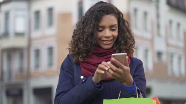 Mujer con estilo en busca de ropa, activamente surfeando tiendas en línea en el teléfono inteligente — Vídeo de stock