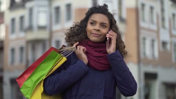 Fiatal nő verseny keverve hívás taxi, elégedett a vásárlás, bevásárló táskák — Stock videók