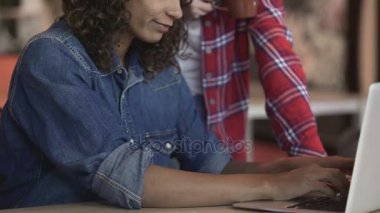 Dizüstü bilgisayarda yazarak ve meslektaşı ile serbest, worktime konuşurken karışık yarış kız