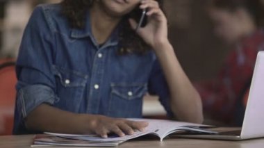 Mutlu biracial Bayan telefonda konuşurken ve dergide fotoğrafların görüntülenmesi