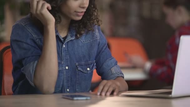 Menina biracial atraente fazendo chamada de vídeo no laptop, conversando com o amigo — Vídeo de Stock