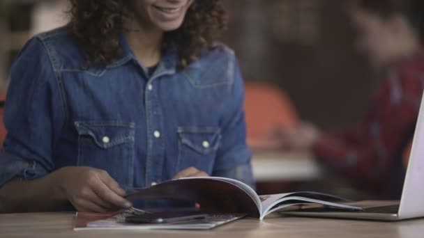 Curly menina de raça mista olhando através de fotos na revista turística, viagem de planejamento — Vídeo de Stock