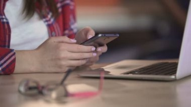 Neşeli kız telefonu, iş, sosyal ağlar, kahve molası sayfalarında kaydırma