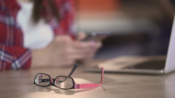 Junge hübsche Frau textet im Café auf dem Smartphone, Freiberuflerin in der Pause — Stockvideo