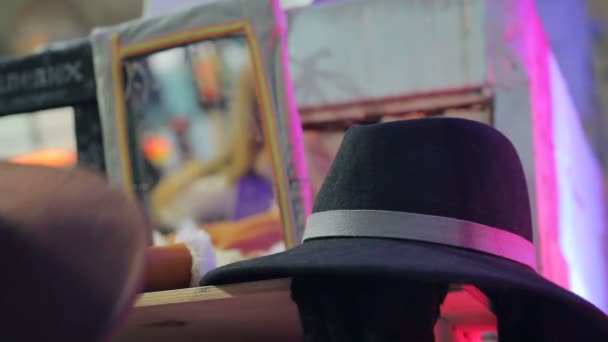 Женщина эксперт моды примеряет различные шляпы, ищет индивидуальный стиль — стоковое видео