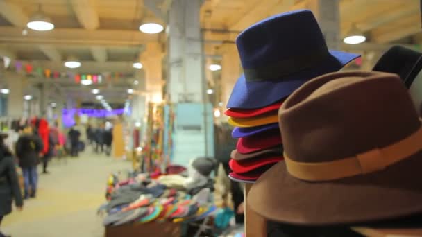 Люди ходят по магазинам на местном рынке, выбирают одежду и аксессуары в продаже — стоковое видео