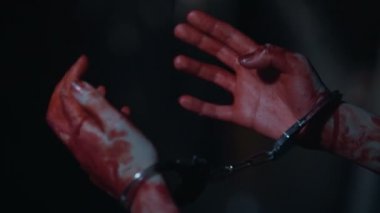 Close-Up kanlı titreyen katilin ellerinde kelepçe, suç ve ceza