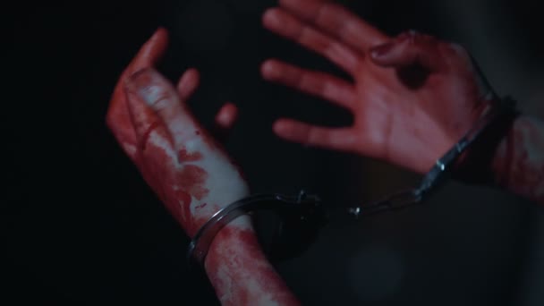 Primer plano de las manos del sangriento y tembloroso asesino esposado, criminal y castigado — Vídeos de Stock