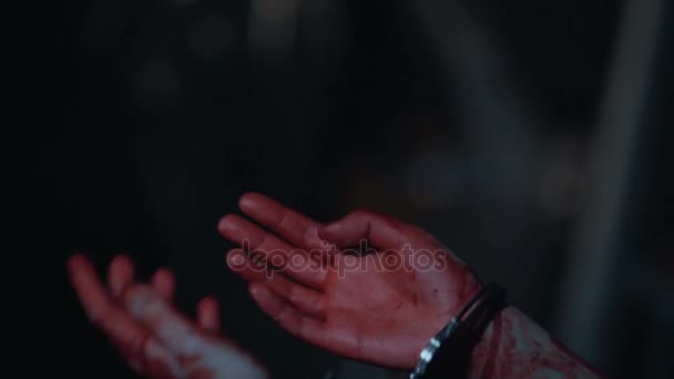 Amnesiac moordenaar misdrijf een, close-up van bloedige handen in handboeien — Stockvideo