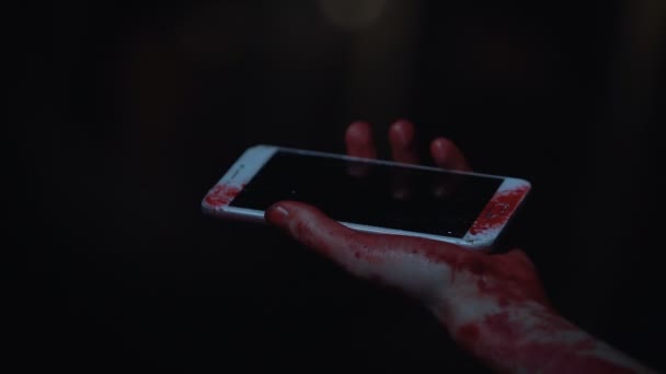 Bang slachtoffer van terroristische aanslag bloedige smartphone in de hand houden — Stockvideo