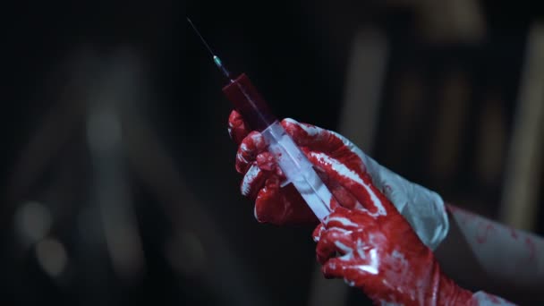 Persona loca con guantes de látex sosteniendo jeringa con sangre, crimen, horror — Vídeo de stock