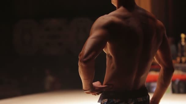 Lekkoatletycznego mężczyzna stojąc na scenie i wykazując muskularne ciało w zawodach sportowych — Wideo stockowe
