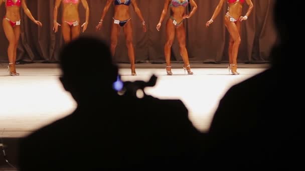 Cameraman silhueta gravação de vídeo do concurso de beleza, modelos posando no palco — Vídeo de Stock