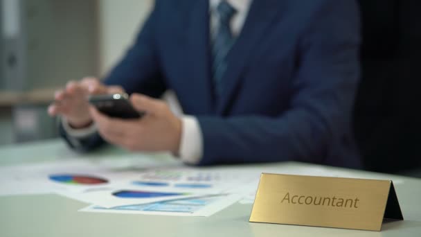 Firemní účetní v podnikání vyhovují psaní zpráv na telefonu, papíry na stole — Stock video