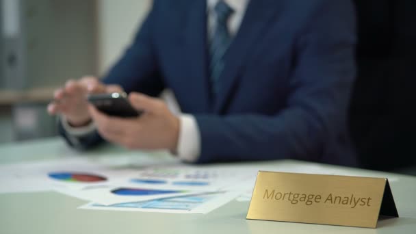 Analista hipotecário competente que trabalha com dados do mercado imobiliário, usando gadget — Vídeo de Stock