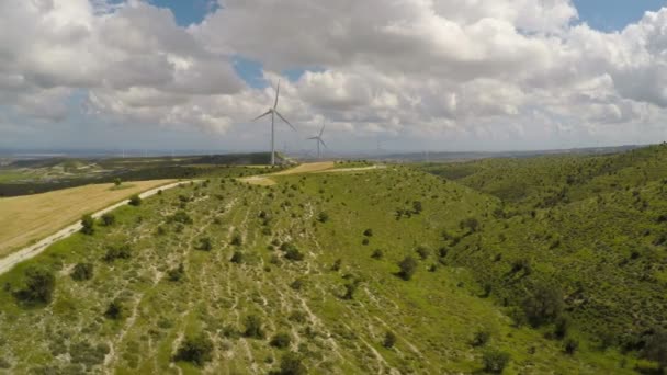 Lopatky větrných turbín otáčení za zatažené obloze, fantastický zelená krajina — Stock video
