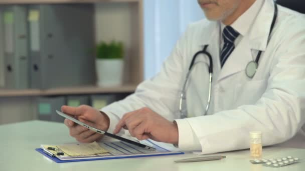 Männlicher Arzt scrollt Informationen auf Tablet, Online-Beratung, Gesundheitswesen — Stockvideo
