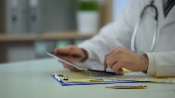 Чоловік-лікар введення інформації про медичне страхування в онлайн-реєстрі на планшеті — стокове відео