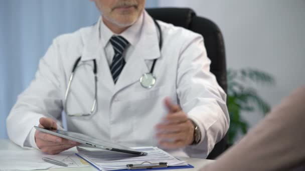 Médico digitando os dados do paciente em tablet, mantendo registros médicos, consulta — Vídeo de Stock