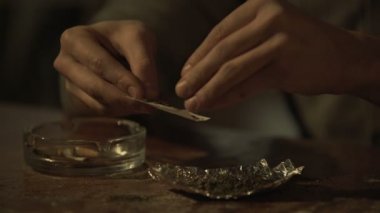 Genç adam kronik ağrı gidermek için tıbbi marihuana çalışırken sigara eller