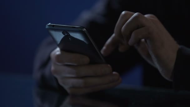 Hombre escribiendo mensaje en el teléfono inteligente, perdiendo el tiempo en la fiesta de la noche, las manos de cerca — Vídeos de Stock