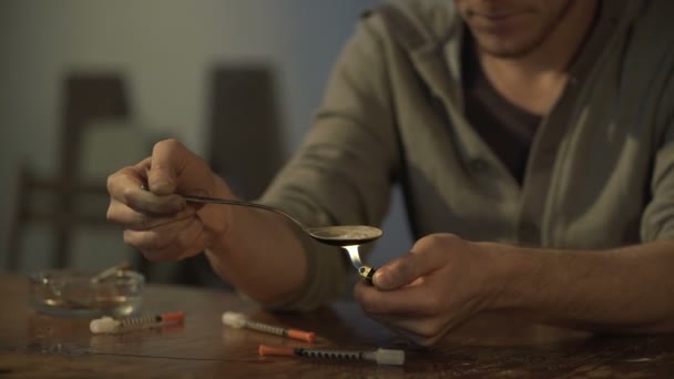 Homem sentado na sala abandonada, preparando a dose da droga para a injeção, sequência vídeo — Vídeo de Stock