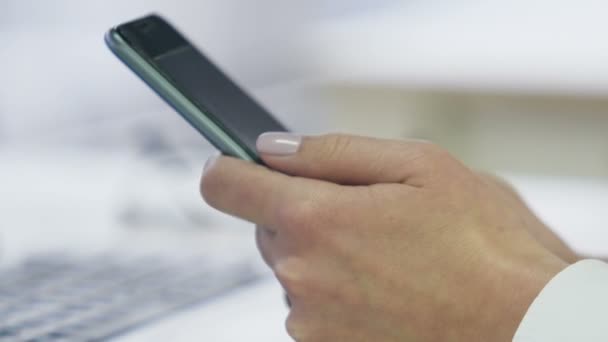 Руки женщины печатают сообщения на современных смартфонах, коммуникационных технологиях — стоковое видео