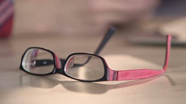 Gros plan de lunettes sur la table, de beaux accessoires pour les personnes ayant une mauvaise vue — Video