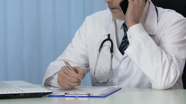 Terapeuta da clínica conversando por telefone, marcando consulta com o paciente — Vídeo de Stock