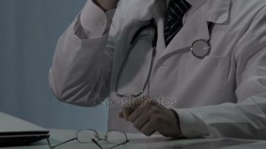 Mola sırasında dinlenmek için gözlük alarak nöbetçi overworked erkek doktor