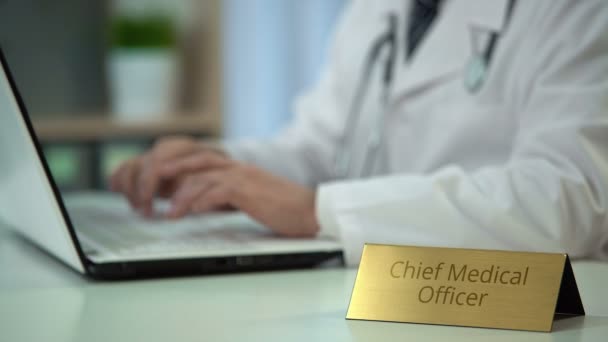 Mani di chief medical officer ordinare farmaci online, digitando sul computer portatile — Video Stock