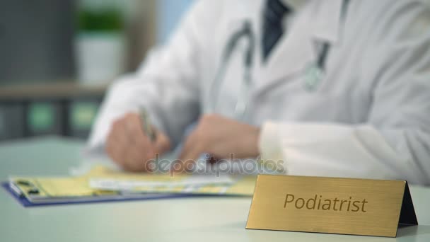 Podiatrist prescribing medication to patient, completing medical documents — Stock Video