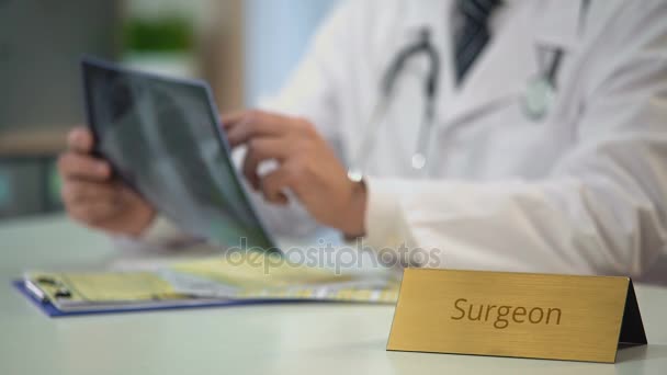 Professionella kirurgen tittar på röntgen och skriva ner diagnos, vård — Stockvideo