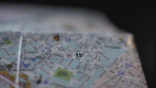 Закрытие карты французского города, рука туриста, обозначающая место поездки значком — стоковое видео