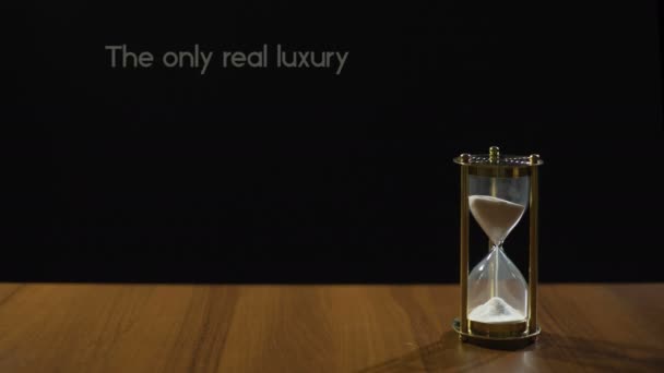 Tiden är bara riktig lyx, populär fras om liv värde, timglas på bord — Stockvideo