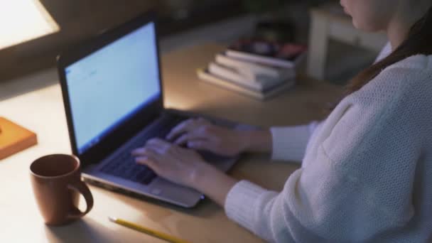 Femme confiante travaillant sur son projet sur ordinateur portable assis à la bibliothèque — Video