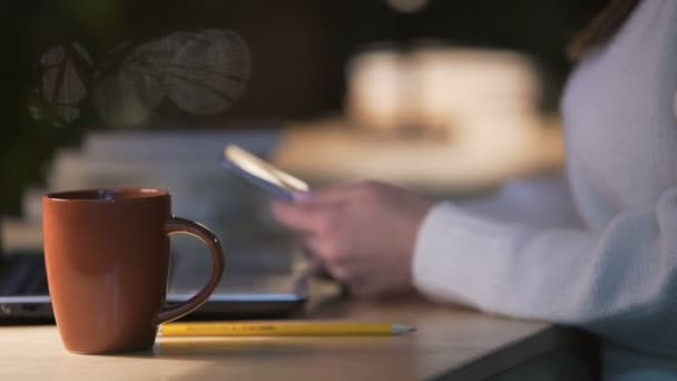 Леди, сидящая в кафе, пьет кофе и просматривает интернет по мобильному телефону — стоковое видео