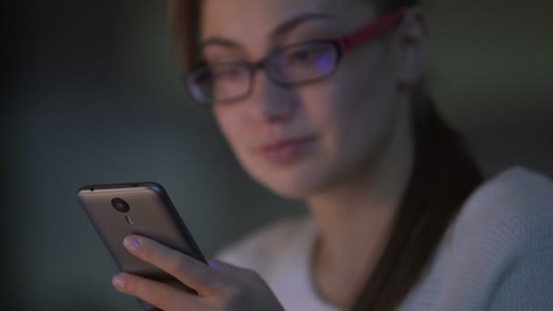 Jeune femme naviguant sur les pages sur smartphone, en utilisant une application mobile, magasinage en ligne — Video