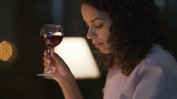 Mujer joven bebiendo vino en el restaurante, navegando por la red social en el teléfono inteligente — Vídeo de stock