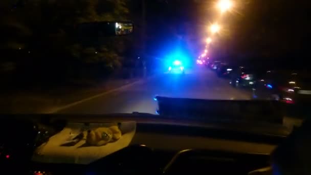 Полицейская машина спешит к вызову скорой помощи, преследует преступника на ночной городской улице — стоковое видео
