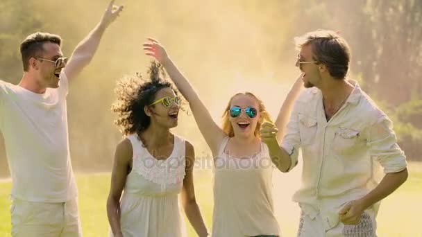Two young couples raising hands and dancing at Holi festival, super-slow motion — Stock Video