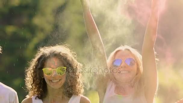 Deux couples dans des lunettes de soleil jetant ludique peinture en poudre à l'autre, slow-mo — Video