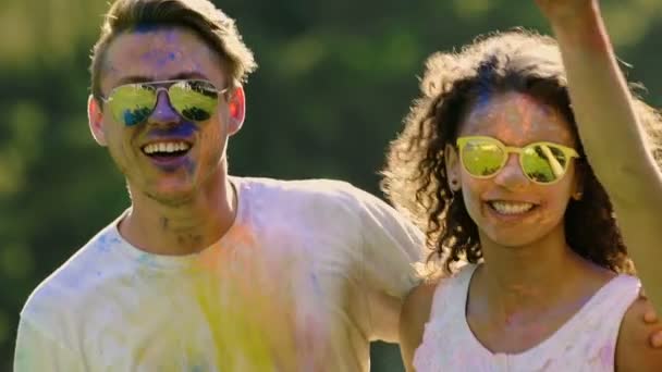 Jovens pessoas atraentes abraçando, dançando no festival de cores ao ar livre, câmera lenta — Vídeo de Stock