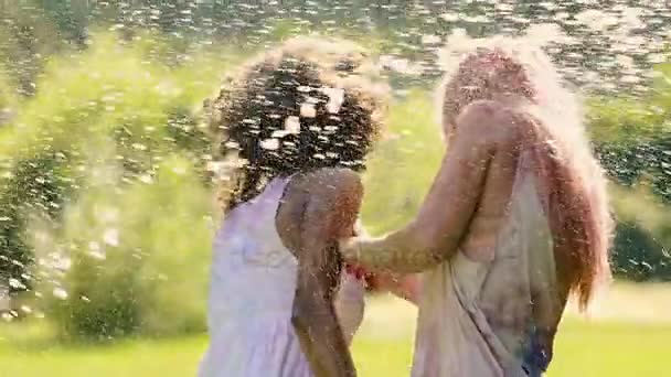 Mujeres jóvenes felices alejándose de salpicaduras de agua en la fiesta, cámara extra lenta — Vídeo de stock