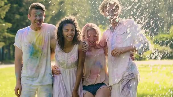 Glückliche Freunde werden bei sommerlicher Outdoor-Party mit Wasser bespritzt, echte Freundschaft
