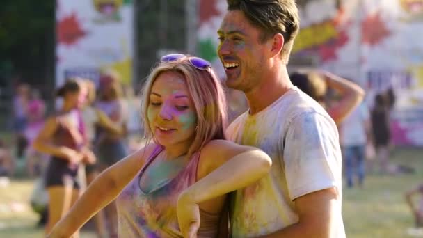 Hermosa chica rubia coqueteando y bailando con su novio en el festival Color — Vídeos de Stock