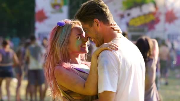 Happy beautiful couple hugging and dancing at open-air Color festival, slow-mo — Stock Video