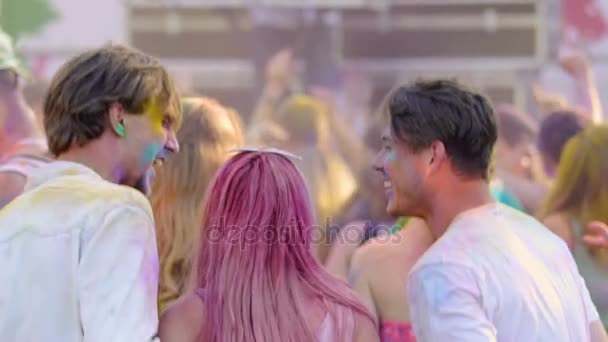 Tres jóvenes amigos bailando en multitud en el festival Color, volviendo a la cámara — Vídeos de Stock