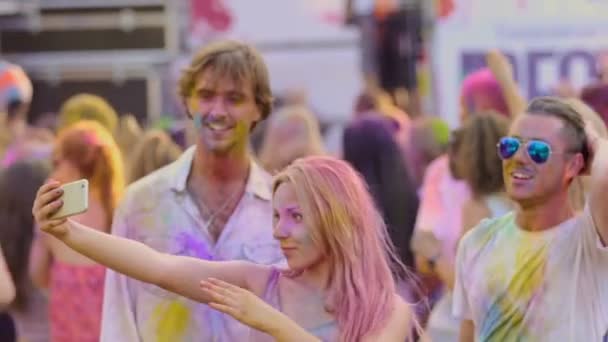 Happy vrienden poseren voor de camera, airkisses verzenden op traditionele festival van de kleur — Stockvideo