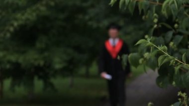 Yürüme ve Park, mezuniyet sevinçle atlama akademik elbiseli erkek öğrenci